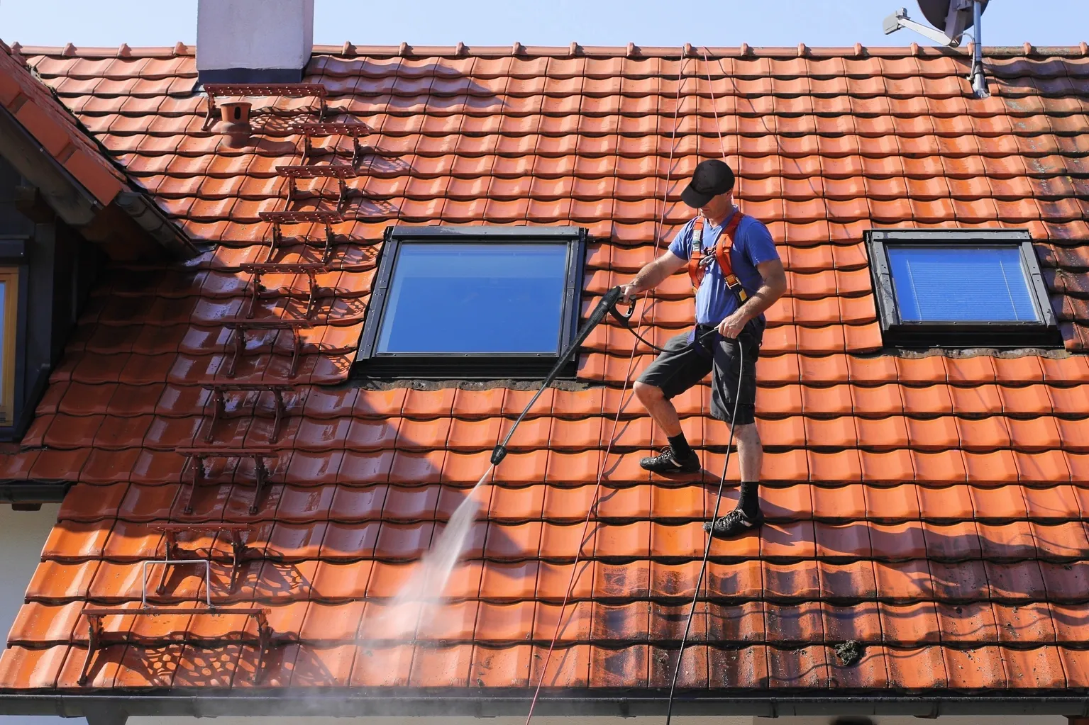 Pristine Powerwash team member washing roof.